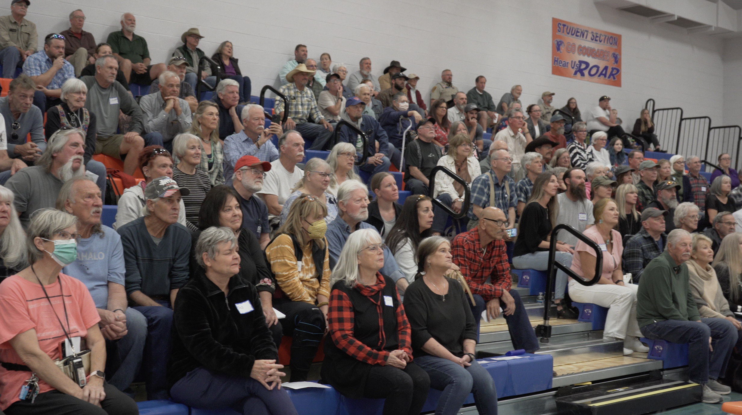 Rural crowd in bleachers listening to Attorney General Kris Mayes.